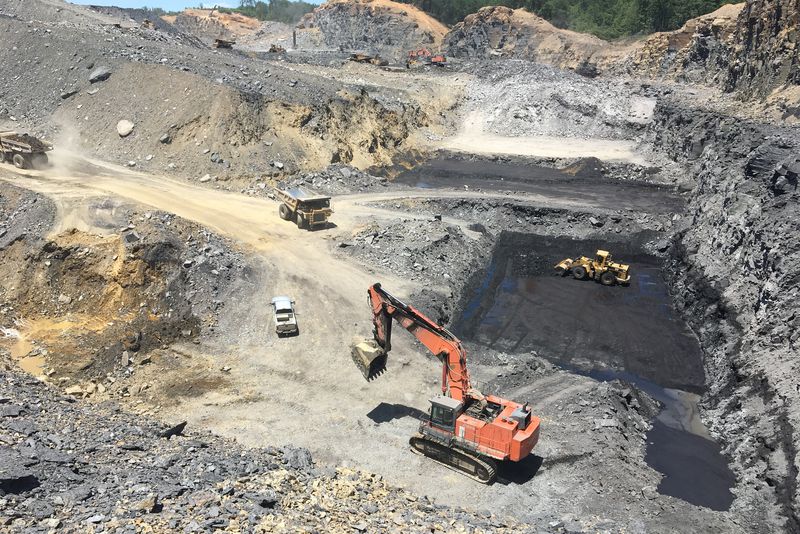 Rock quarry dig site with excavator and dump trucks, showing geology, earth science, and mining machines for kids.