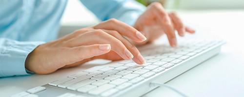 a person sitting on the keyboard of a laptop computer