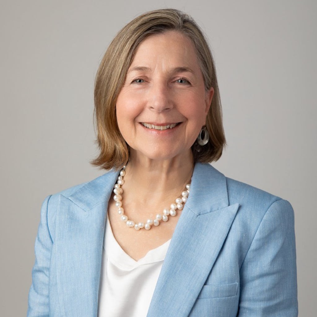 Portrait of a woman in a light blue blazer, smiling; children's science center educator supporting STEM learning.
